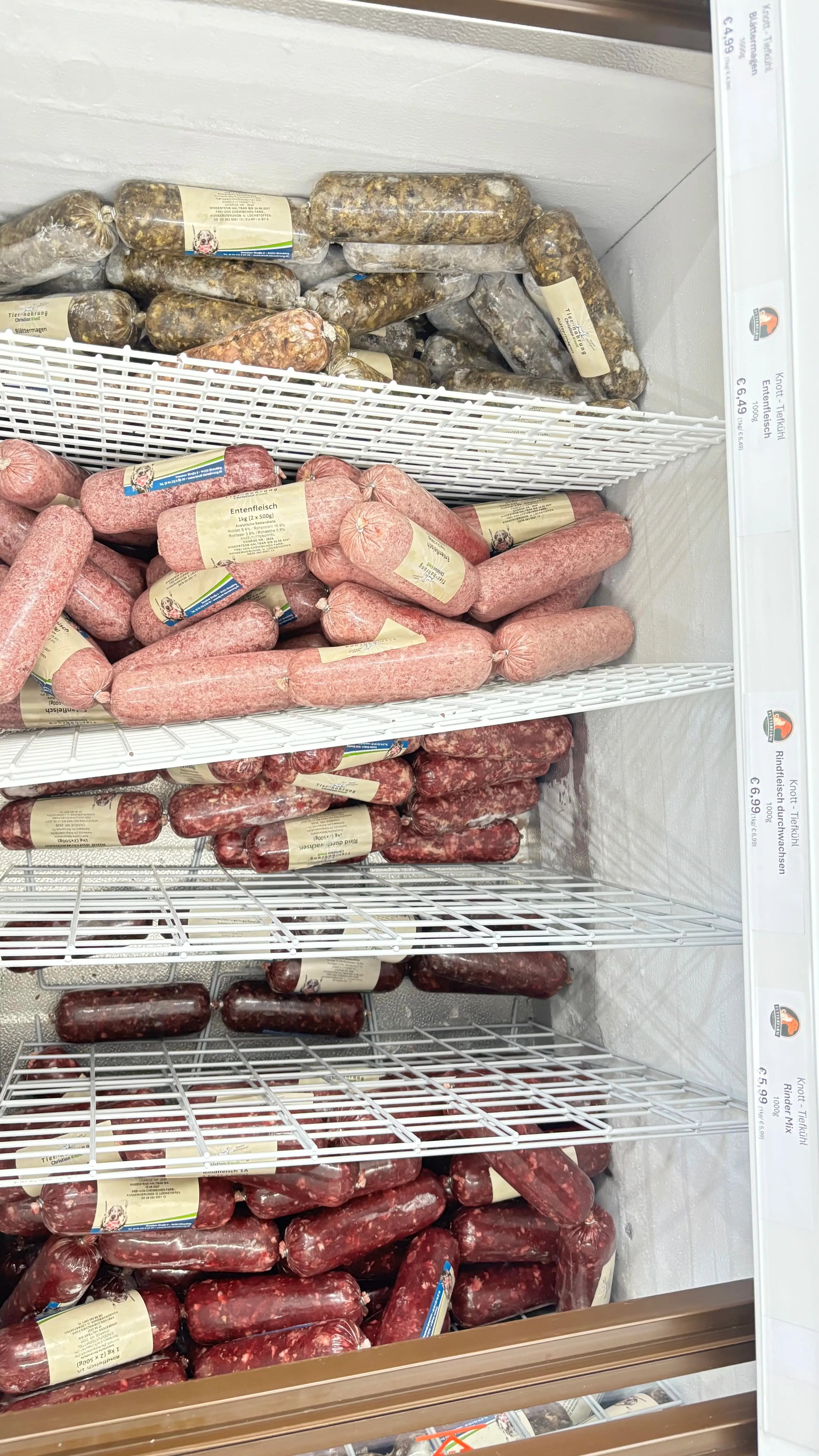 Tiefkühlregal mit gefrorenem Frostfleisch in praktischen Portionen